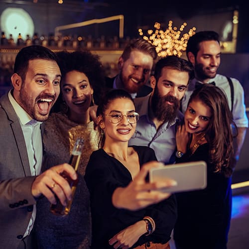 Un instantané joyeux d'amis célébrant ensemble, capturant le moment avec un selfie.